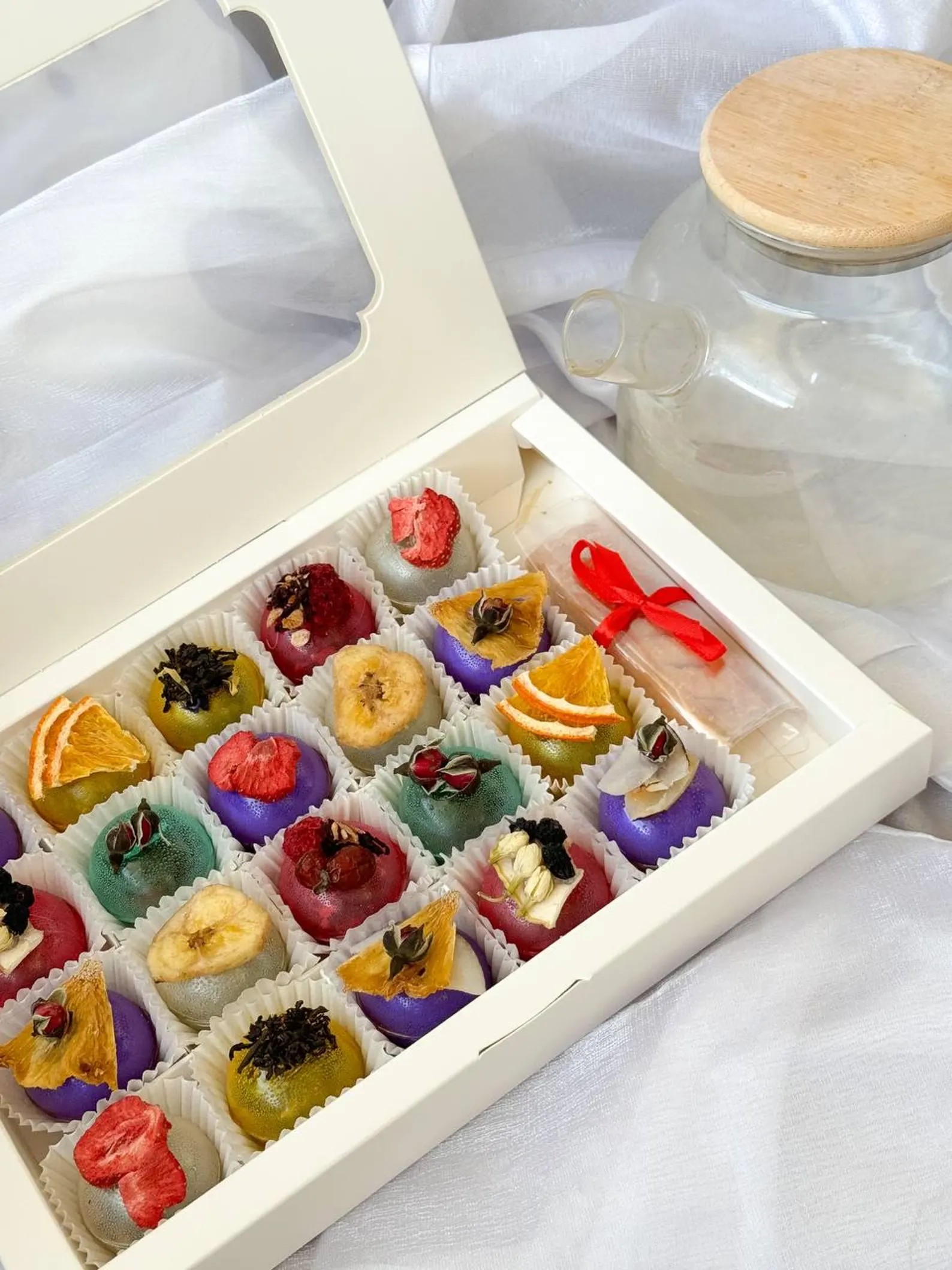 Box of colourful fruit tea bombs decorated with dried fruit