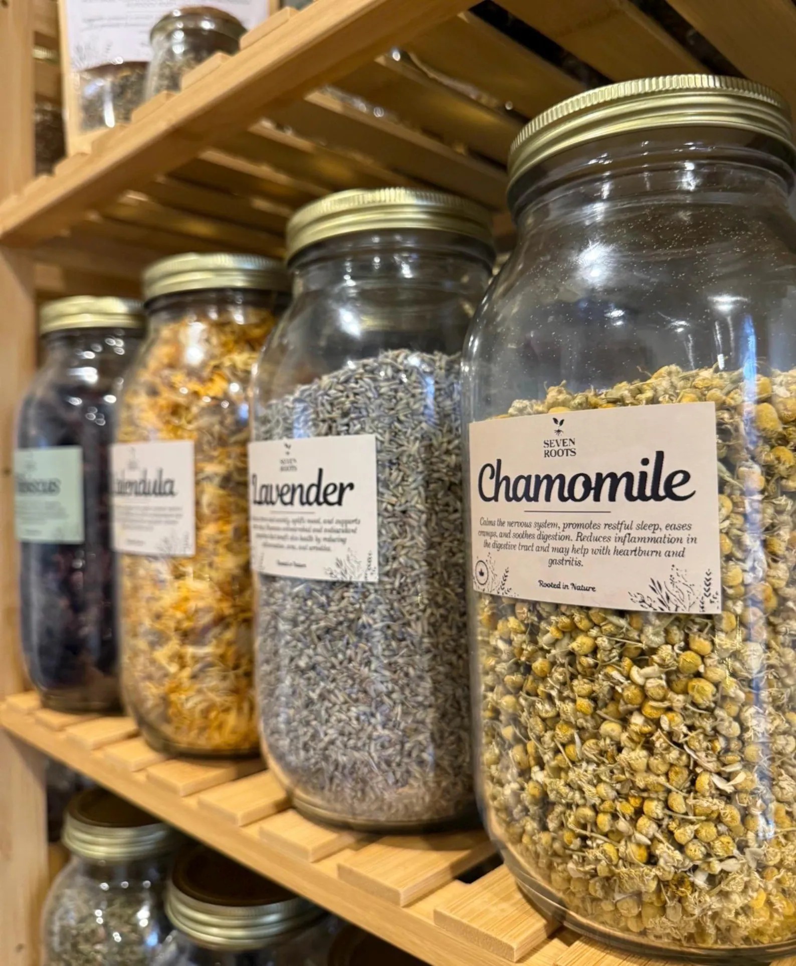 Jars of loose leaf herbs on wooden shelves