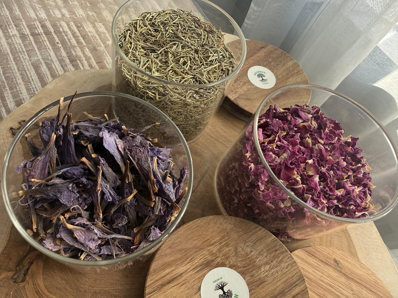 Three glass bowls with rosemary, rose petals and dried mallow